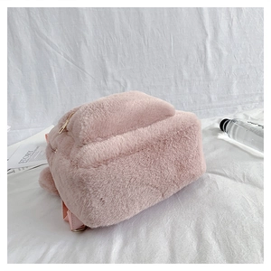 Close-up of pink plush backpack with soft faux fur texture and metallic zipper details