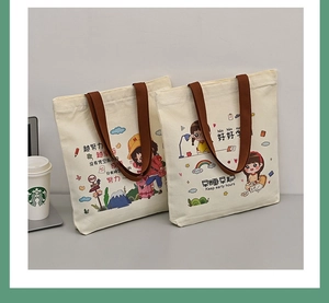 Detail shot of canvas tote bag featuring motivational illustrations and woven handles
