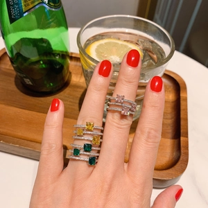 Detail of stacked multi-layer rings with square-cut pink and colorful gemstones