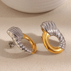 Detailed view of bicolor twisted hoop earrings in 18K gold and silver plating