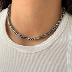 Heavy metal woven mesh necklace in polished stainless steel worn by a model