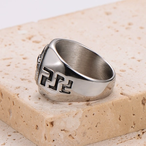 Detail view of vintage stainless steel ring with geometric carvings on stone base