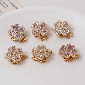 Detail of floral zircon rotating clasps for jewelry making in gold with purple and pink stones