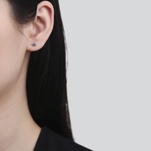 925 silver star stud earring with blue zircon stone worn by a female model