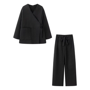 Flat lay of black quilted loungewear set with kimono tie top and drawstring pants