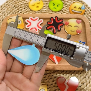 DIY acrylic emoji charms with 50.00mm digital caliper measurement on wooden tray