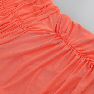 Detail shot of bright orange ruched mesh fabric showing fine texture and pleats