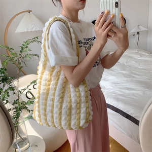 Detail of yellow and white striped bubble texture on a knit tote bag for women