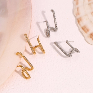 Detail of 18K gold and silver plated asymmetric geometric earrings with shiny crystals