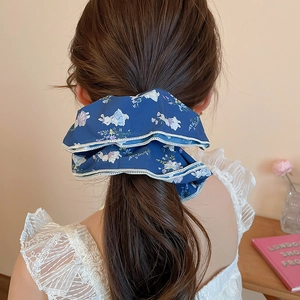 Detail view of navy blue floral scrunchie with rabbit print on a messy ponytail hairstyle