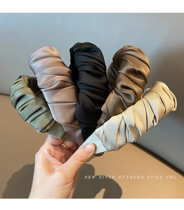 Detail shot of pleated satin headbands in military green, purple, black, coffee, and beige