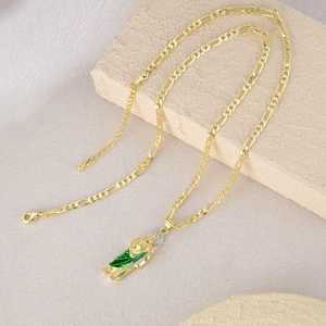 Hip hop gold Figaro chain necklace featuring St. Jude pendant with green enamel and stones