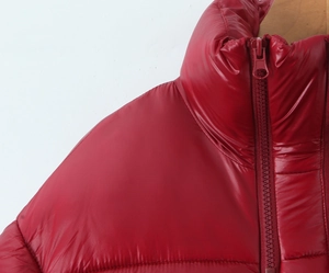 Close-up of red puffer jacket showing high neck collar, windproof fabric and zipper detail