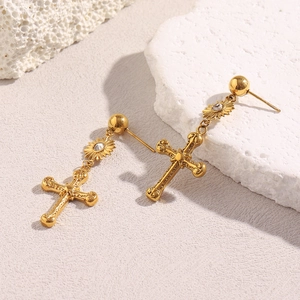 Détail de boucles d'oreilles croix en acier inoxydable plaqué or 18 carats avec gemme