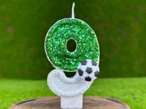 Macro d'une bougie d'anniversaire numéro 9 à paillettes vertes avec un mini ballon de foot