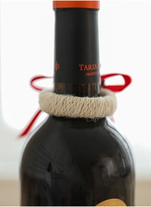 Detail of woven cream cotton napkin ring and wine bottle collar for Christmas table setting