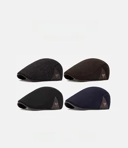 Flat lay detail of wool beret hats in four colors with side metal tag accents