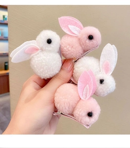 Vue détaillée des barrettes lapin en peluche rose et blanche à texture douce