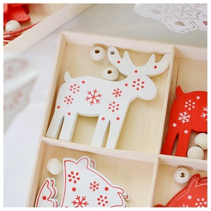 Close-up of red and white wooden reindeer ornaments with snowflake patterns in a wooden box