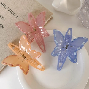Detailed close-up of three colorful butterfly hair claws with delicate stitch patterns