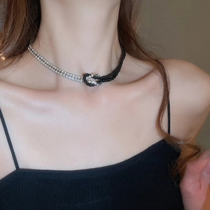 Dettaglio collana Y2K con catena in strass argento e nodo in cordino di perline nero