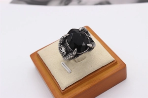 Makroaufnahme von gotischem Drachenkrallen-Ring mit facettiertem schwarzem Stein und Schuppen