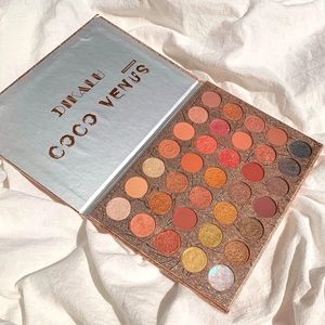 Palette di 35 ombretti con texture opache e brillanti posata su un panno bianco