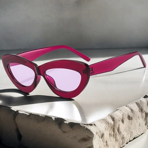 Détail de lunettes de soleil œil-de-chat avec monture bordeaux et verres lavande