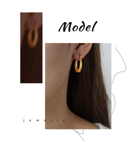 Detalle de pendientes en forma de U bañados en oro con textura sobre una modelo