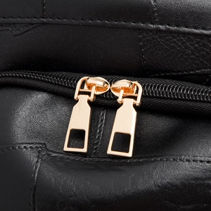 Macro shot of high-quality black leather texture with dual gold metal zippers
