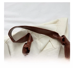 Detail of the knotted brown faux leather strap on a minimalist large tote bag