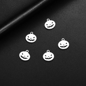 Set of 5 silver pumpkin face pendants for DIY Halloween jewelry on black leather background