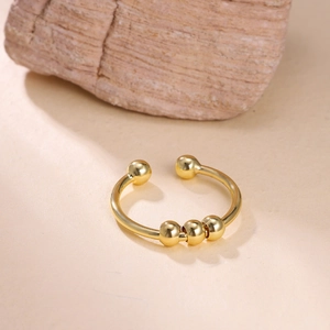 Macro detail of 18k gold spiral bead ring showing smooth texture on stone backdrop