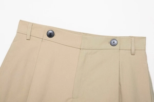 Detail of khaki twill shorts featuring double button closure and high-density fabric texture