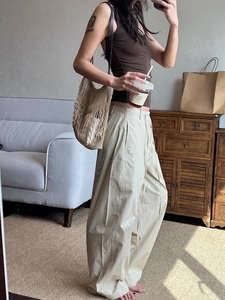 Detail of beige wide-leg cargo pants with drawstring waist and loose fit design
