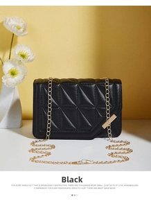 Detail of black quilted crossbody bag with gold chain strap and elegant floral background