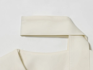 Dettaglio della cucitura a V su un blazer in tessuto beige con trama visibile e definita