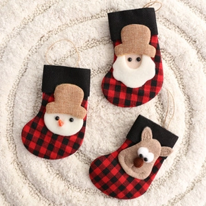 Close-up of three mini Christmas stockings with Santa, snowman and reindeer on plush rug