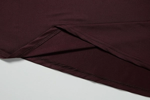 Dettaglio dell'orlo del vestito bordeaux con cucitura a doppio ago e trama del tessuto