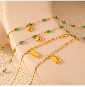 Detailed view of green beads and gold shell pendant on titanium steel anklet chain