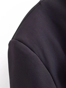 Detailed view of black blazer shoulder stitching and smooth fabric texture close-up