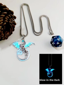 Detailed view of silver dragon pendant showing glowing ice blue wings in darkness