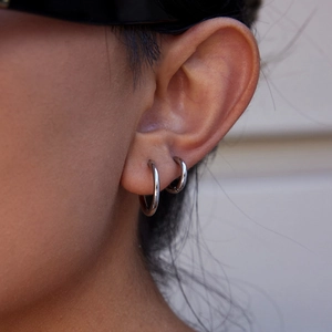 Boucles d'oreilles créoles argentées en acier inoxydable pour femmes sur modèle