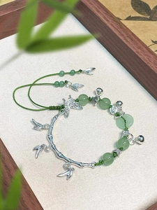 Detail view of Chinese style butterfly bamboo bracelet with green beads and silver charms