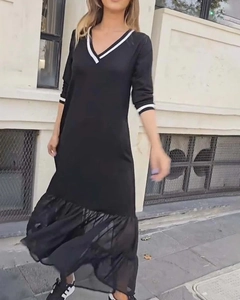 Détail d'une robe noire élégante à col en V avec rayures blanches et ourlet en tulle