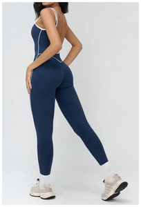 Detail view of the open-back design with white contrast trim on a navy yoga bodysuit