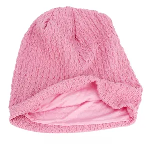 Detail showing the double-layer pink knitted beanie with crochet texture and soft lining