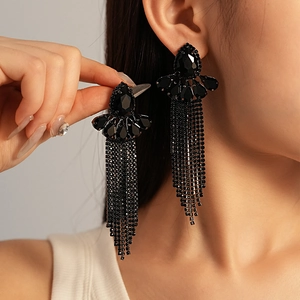 Détail de boucles d'oreilles noires à pampilles avec pierres et chaînes de cristaux