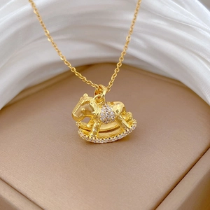 Macro view of a gold-plated rocking horse pendant with sparkling cubic zirconia on silk