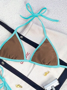 Flat lay of a brown halter bikini top with bright blue contrast trim and ties